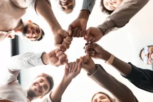 Employees standing in a circle with their fists together