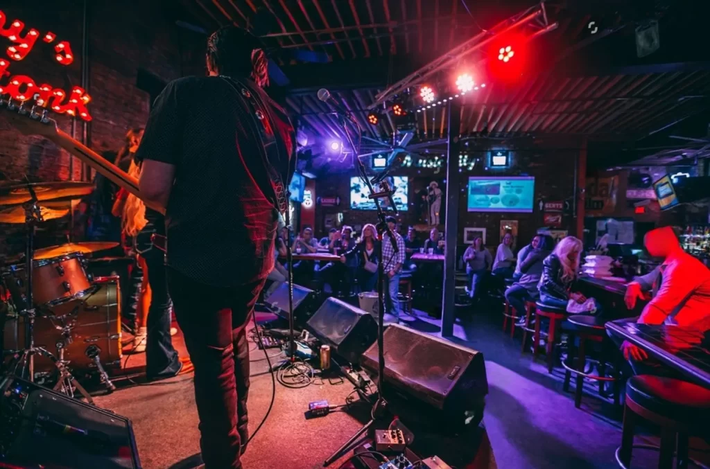 a shot of a band on stage at a bar with only a few patrons in it