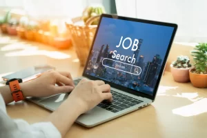 An image of a laptop with the words "Job Search" displayed on the screen